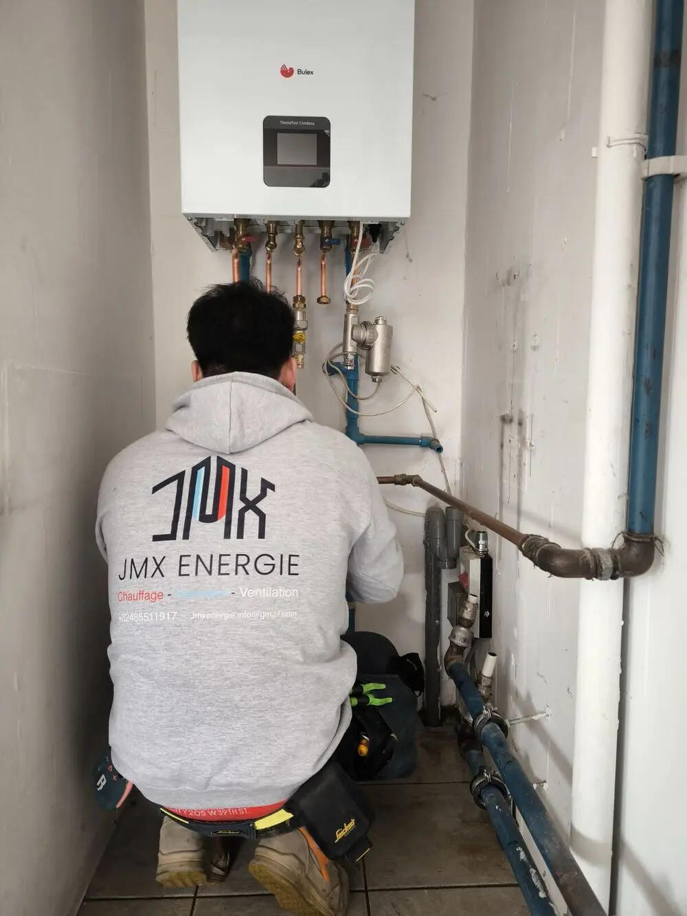 Technicien JMX Énergie raccordant une chaudière Bulex